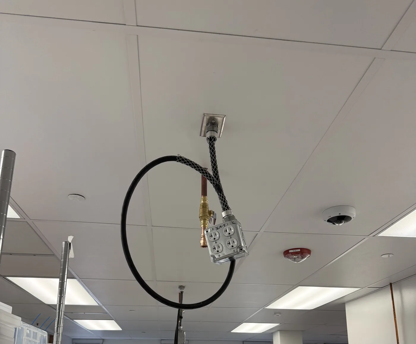 Commercial cord drop supported at T-bar ceiling