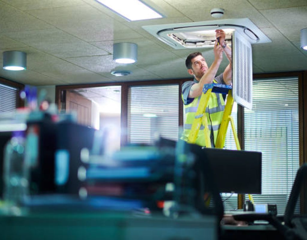 Electrician installing energy efficient LED lighting in large commercial building